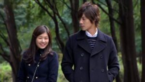 Young couple walking in park, smiling
