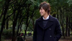Smiling man walking through tree-lined park