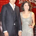 Well-dressed couple holding hands on red carpet