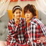 Two young people wearing matching red plaid pajamas