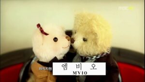 Two teddy bears touching noses on red seat