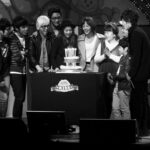 Group celebrating birthday with cake on stage