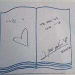Open notebook with heart doodle and signature