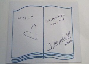 Open notebook with heart doodle and signature