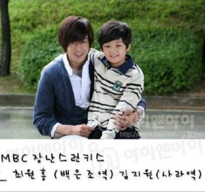 Man and boy sitting outdoors, smiling together