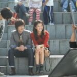 People sitting on outdoor stone steps at event