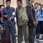 Three men in period clothing with rifle