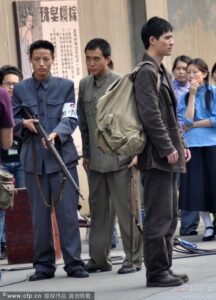 Three men in period clothing with rifle