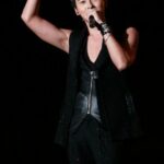 Male singer holding microphone, making heart gesture