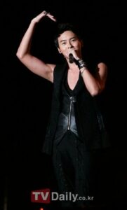 Male singer holding microphone, making heart gesture