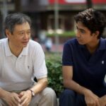 Two men sitting and talking outdoors