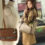 Woman holding designer tote bag in boutique