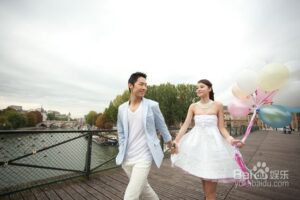 Smiling couple holding balloons walking on bridge