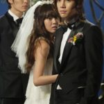 Bride clinging to groom, another man watching