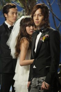 Bride clinging to groom, another man watching