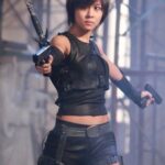 Woman in black tactical outfit aiming pistols