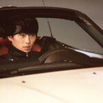 Young man driving white convertible car