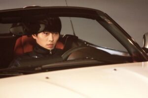 Young man driving white convertible car