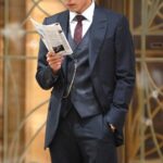 Man in navy suit reading brochure
