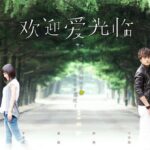 Two people back-to-back on tree-lined road