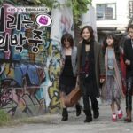 Four friends walking past graffiti-covered wall