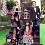 Four people posing on steps with potted plants