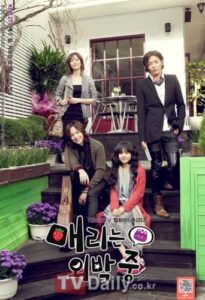 Four people posing on steps with potted plants