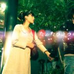 Two people holding hands on night street