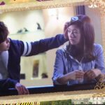 Man reaches toward woman's face in framed scene