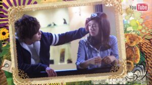 Man reaches toward woman's face in framed scene