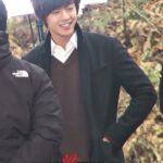 Smiling young man outdoors wearing dark coat