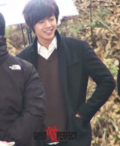Smiling young man outdoors wearing dark coat