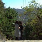 Two people hugging on hillside overlooking town