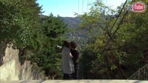 Two people hugging on hillside overlooking town