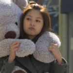 Woman hugging oversized teddy bear outdoors
