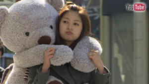 Woman hugging oversized teddy bear outdoors