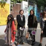 Four friends smiling on graffiti-covered urban street