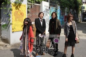 Four friends smiling on graffiti-covered urban street