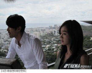 Two people on balcony overlooking coastal cityscape