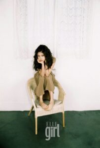 Young woman sitting barefoot on wicker chair
