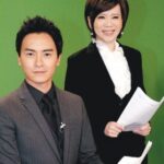 Two TV news anchors holding papers