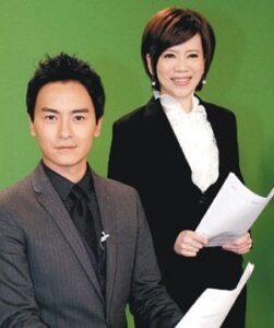 Two TV news anchors holding papers