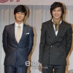 Two men in suits standing and smiling
