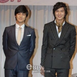 Two men in suits standing and smiling