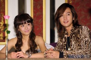 Two people seated at table smiling