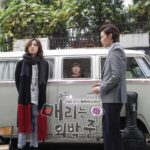 Two people standing beside van with passenger