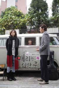 Two people standing beside van with passenger