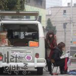 Women by open vintage van in urban alley