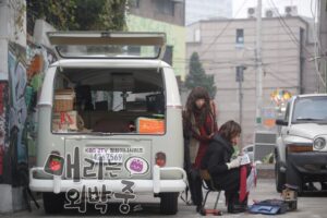 Women by open vintage van in urban alley