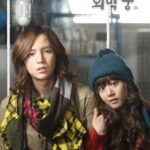 Two people in winter clothes on swing